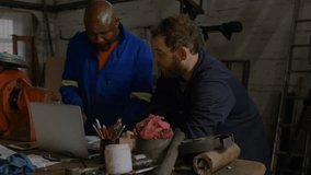 Technician tapping laptop and colleague leaning generating social icons mapping workshop workflow. Collaboration, innovation, industrial, technology, networking, automation, engineering - Powered by Shutterstock - Get 15% off with code: PIKWIZARD15