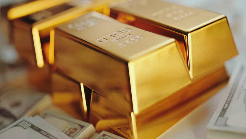 Stacks of pure gold bars and one hundred dollar bills representing wealth, investment, and success in the financial market, showing the high value of precious metals and cash reserves