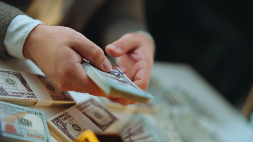 Close-up of a businessman's hands counting a large stack of one-hundred-dollar bills, representing wealth, financial success, and profit from a successful investment or business deal