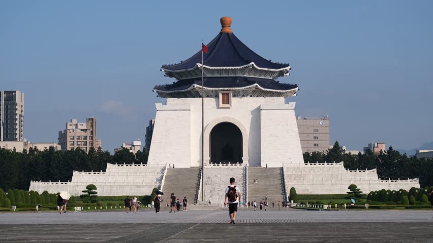 Chiang Kai-shek Memorial Hall (中正紀念堂) in Taipei, Taiwan, a national monument and historical landmark. Tourists walk across Liberty Square, the outdoor plaza with traditional Chinese architecture