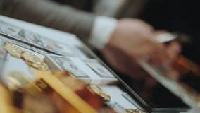 Businessman in a suit managing investments, surrounded by stacks of hundred-dollar bills, gold coins, and gold bars, symbolizing wealth, finance, success, and the accumulation of capital - Powered by Shutterstock - Get 15% off with code: PIKWIZARD15