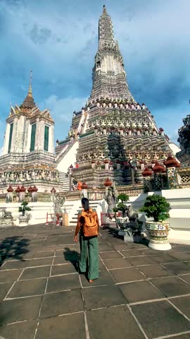 Asian woman discover the beauty of Wat Arun in Thailand, featuring intricate architecture and vibrant colors. Visitors admire the temples stunning spires and rich cultural heritage