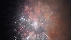 Multicolored fireworks against black sky on holiday. Festive background video with pyrotechnic figures in form of balls and stars exploding simultaneously in sky. - Powered by Shutterstock - Get 15% off with code: PIKWIZARD15