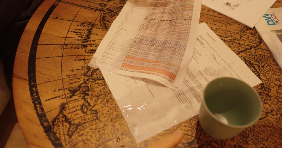 Office papers soaked with water after a drink was accidentally spilled on the table, showing the damage and texture of wet documents.