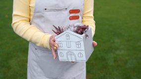 A girl holds a succulent house in her hands.  - Powered by Shutterstock - Get 15% off with code: PIKWIZARD15