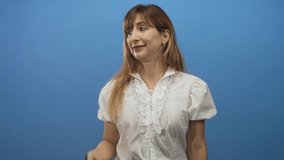 Woman presenting open hand palm up in studio with blue backdrop, smiling and offering gesture; friendly welcome. - Powered by Shutterstock - Get 15% off with code: PIKWIZARD15