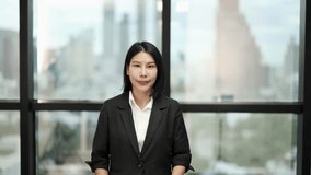 Asian businesswoman in suit gestures and smiles, natural light, cityscape background, static camera - Powered by Shutterstock - Get 15% off with code: PIKWIZARD15