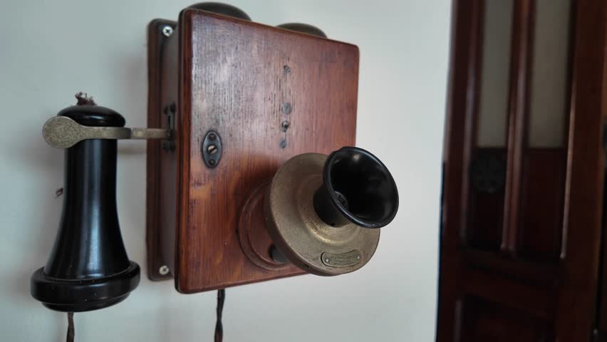 Vintage Wooden Wall Telephone Close-Up with Retro Communication Detail. Documentary early days of global telecommunication.