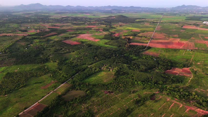 Aerial farmland landscape with colorful fields and mountain ranges in distance