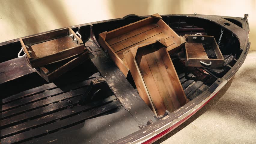 On the shore there is an old wooden boat with wooden boxes inside, which were used to store fish.