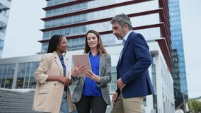 Diverse business team meeting outdoors with a tablet - Powered by Shutterstock - Get 15% off with code: PIKWIZARD15