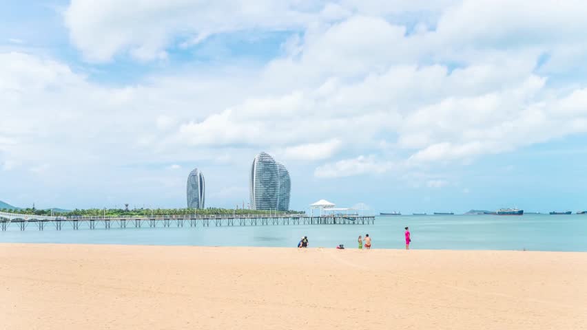 Scenic beach view with modern architecture and pier under a cloudy sky horizon