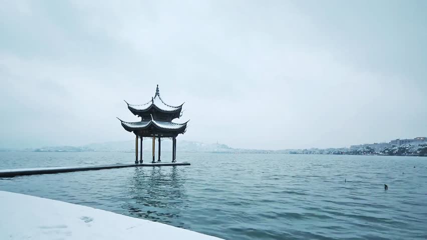 Tranquil winter scene of a pagoda on a lake under a cloudy sky in hangzhou china