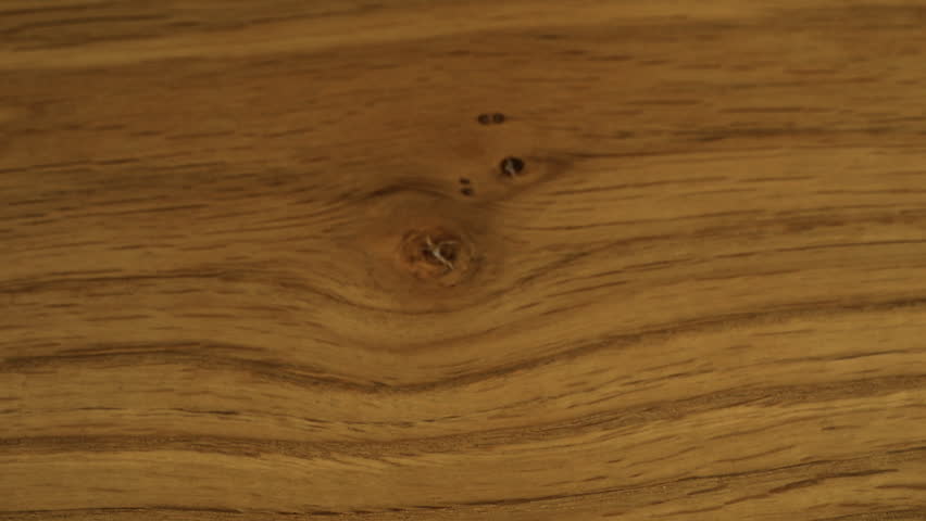 White sugar crystals are sprinkled onto wooden surface. A big pile of sugar, a lot of sugar. Slow motion.