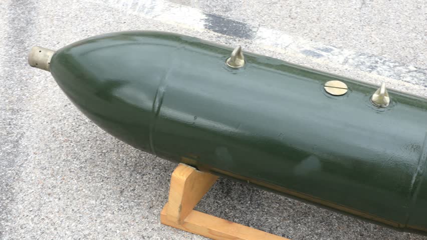 Soviet era unguided aerial bomb displayed on wooden support, representing traditional Cold War weapon later modified into precision guided bomb used in modern warfare during Ukraine conflict