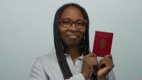 Woman smiling while holding a danish passport against a white background, wearing red glasses and striped shirt; she exudes confidence and joy. - Powered by Shutterstock - Get 15% off with code: PIKWIZARD15