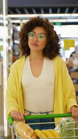 Woman pushing shopping cart in supermarket