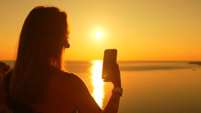 Woman smartphone sunset filming sea travel memories peaceful beautiful - Powered by Shutterstock - Get 15% off with code: PIKWIZARD15
