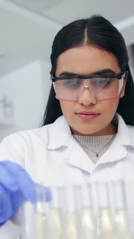 Medical, research and woman in lab, test tube and results with experiment, safety glasses and science. Person, researcher or scientist in workplace, vaccine cure and microbiology with liquid bacteria