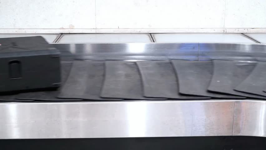 Suitcase on a conveyor belt at the airport waiting to be claimed by its owner