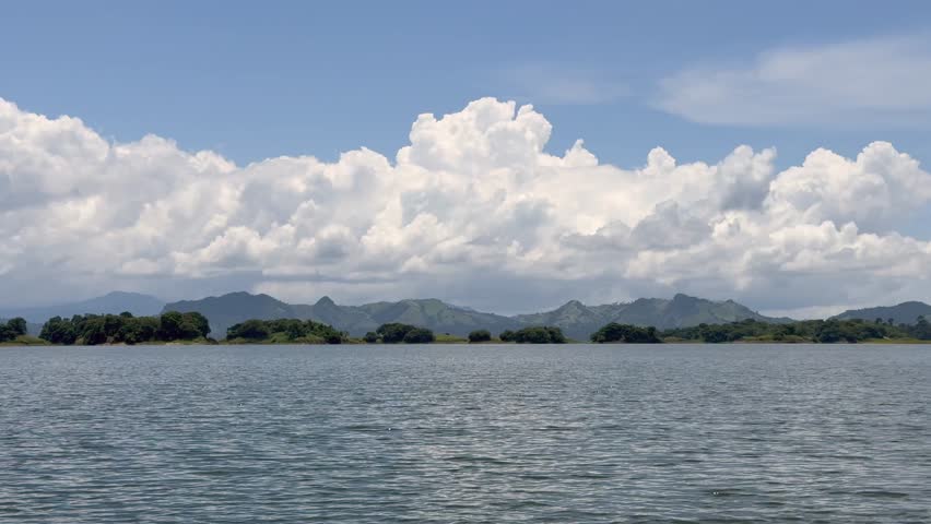 forward view during boat ride across Bayano Lake with wavy water surface ,  lush green rain forest and mountain landscape, near peninsula Akua Yala in Babita de Perro, Panama - 4k video footage
