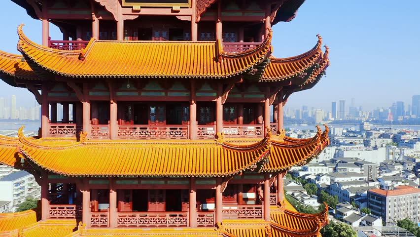 Traditional chinese architecture overlooking a modern cityscape on a sunny day