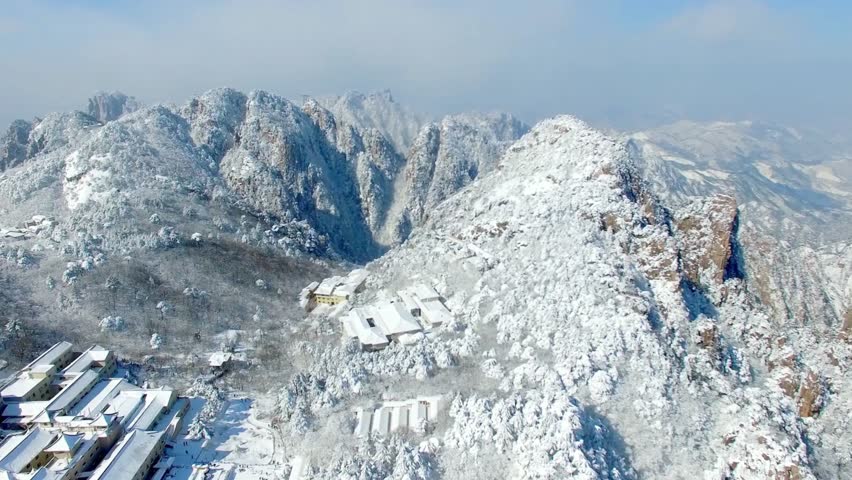 Snow covered mountains and buildings create a serene winter landscape view