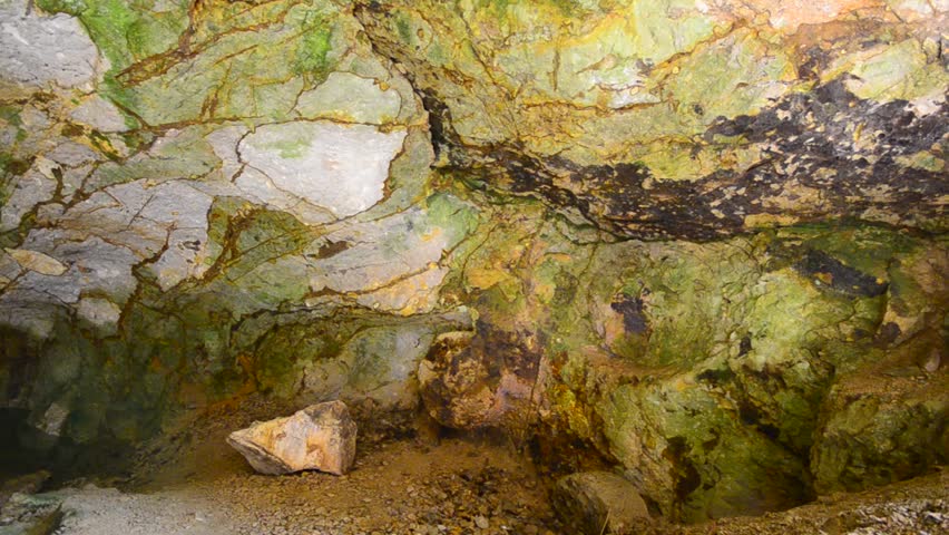 underground cave with colorful walls and clear water lake, dolly shot