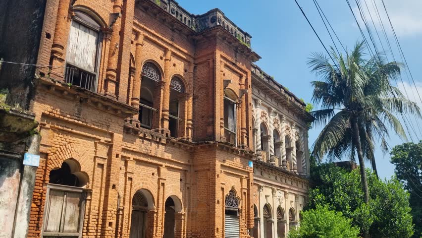 Revealing view of a colonial-era architectural mansion in Panam Nagar, Bangladesh, surrounded by lush tropical greenery, highlighting the town’s historic charm under bright, sunny skies