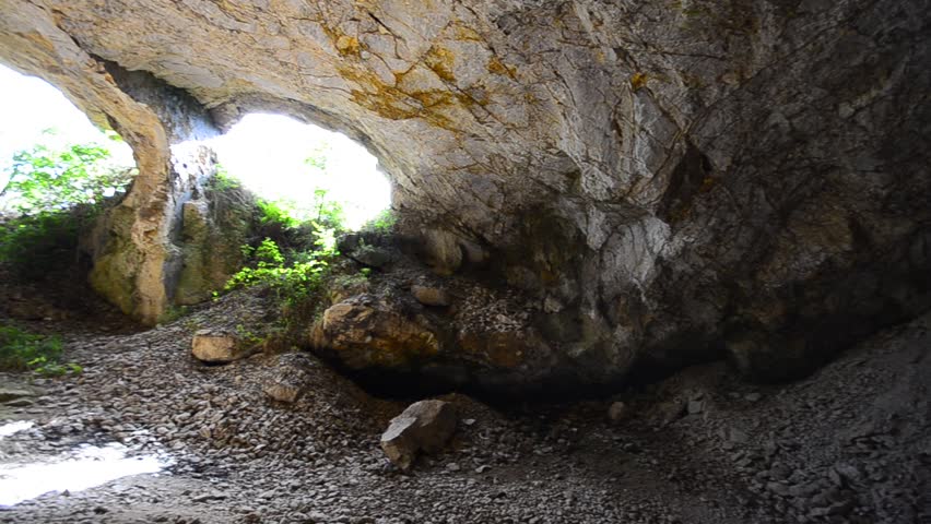 Famous cave entrance, Famous cave of Lesnovo National Park with a creek flowing