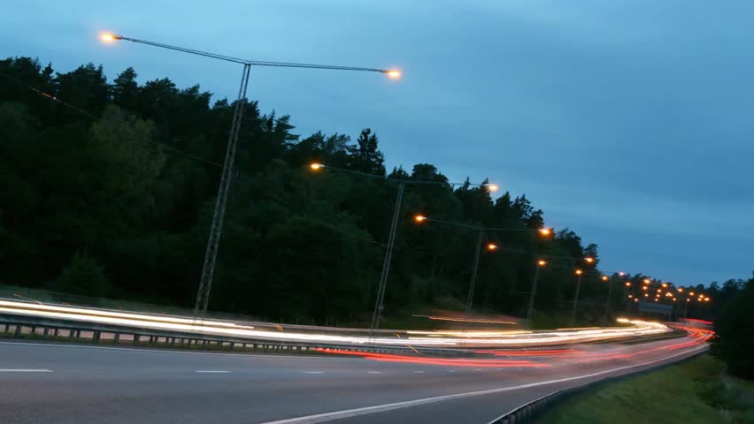 Evening highway traffic with blurred car lights under a twilight sky landscape