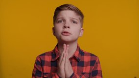Boy Begging Please with Hands Together on Yellow Background - Powered by Shutterstock - Get 15% off with code: PIKWIZARD15