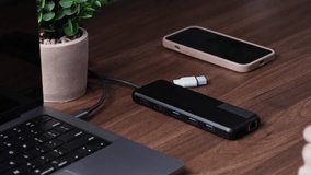 Close-up of a hand inserting a data transfer cable into a black USB-C hub, facilitating enhanced device connection for a seamless remote work setup or professional office - Powered by Shutterstock - Get 15% off with code: PIKWIZARD15
