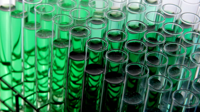 Close up HD video of test tubes filled with green chemicals rotating slowly