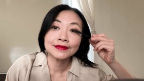 Chinese Asian woman applying mascara in natural daylight, front facing view showing calm focus and confidence. - Powered by Shutterstock - Get 15% off with code: PIKWIZARD15