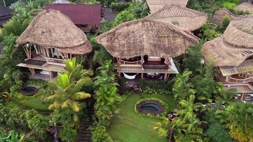 Stunning aerial footage of bamboo villas in Ubud, Bali, featuring thatched roofs, lush tropical gardens, private pools, and green surroundings that create a calm and eco-luxury escape.