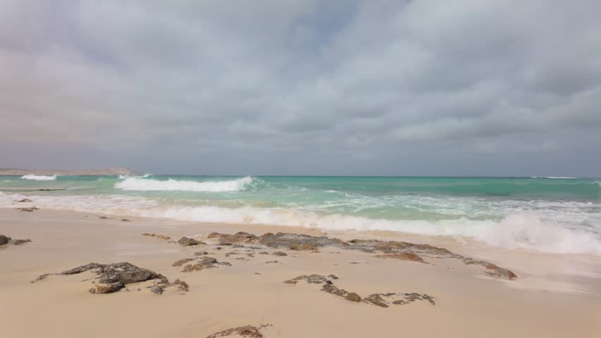 Atlantic Ocean waves breaking over a volcanic rock shoreline of the Cape Verde island of Boa Vista.