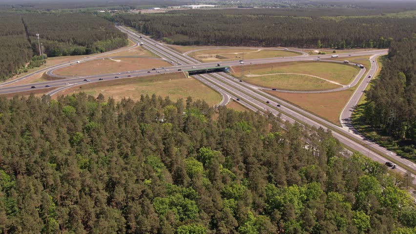 Aerial View of Highway Interchange with Traffic Flow Through Forest