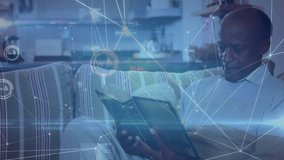 Senior man settling back with book in lounge, initiating technology network overlay while reading. Retirement, leisure, comfort, connectivity, relaxation, modern, home - Powered by Shutterstock - Get 15% off with code: PIKWIZARD15