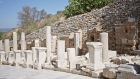 Ephesus ancient ruins defocused marble columns and weathered stone wall in an open archaeological site background outdoor; background backplate copyspace calm. - Powered by Shutterstock - Get 15% off with code: PIKWIZARD15