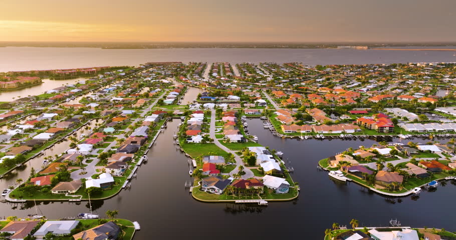 Evening skyline of premium waterfront community in Florida. Expensive homes and mansions under sundown light.