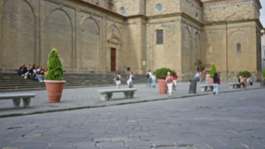 Defocused historic square with blurred stone pavement and terracotta planters in soft focus; background copyspace backplate calm.