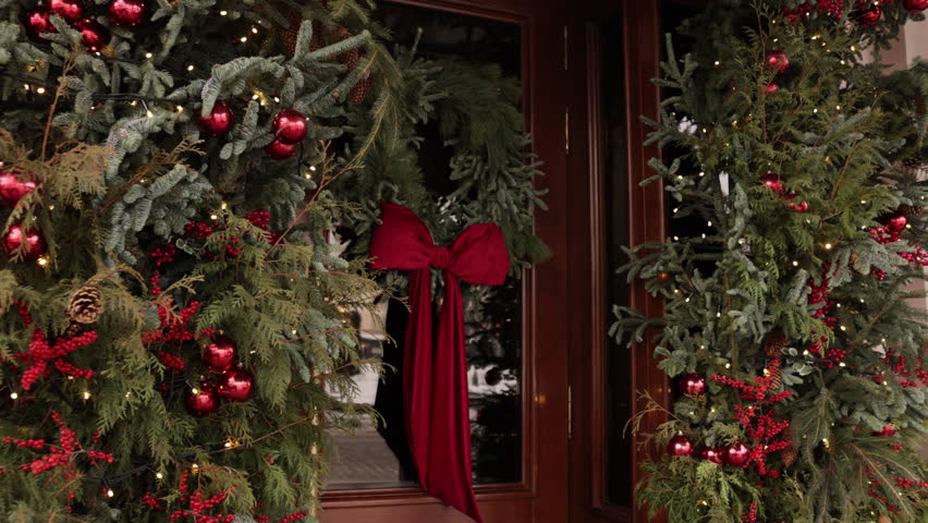 xmas wreath, Decorative element, christmas decorated. Festive front door adorned with pine wreath, red velvet bow, ornaments, berries, and holiday lights during Christmas season.