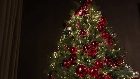 Christmas tree, elegant decor, cozy atmosphere. Beautifully decorated Christmas tree featuring red and silver baubles, warm white string lights, and dense green branches in dark room. - Powered by Shutterstock - Get 15% off with code: PIKWIZARD15