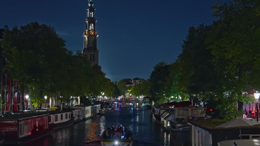 Amsterdam, Netherlands - 20.08.2025: Night view of Amsterdam cityscape with canal, bridge and medieval houses