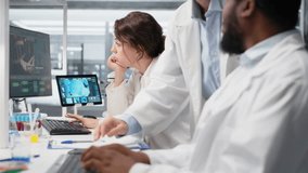 Laboratory manager oversees scientists working on computer, processing DNA data. Lab team leader and employees looking at genetic analysis diagnostics, brainstorming scientific breakthroughs, camera B - Powered by Shutterstock - Get 15% off with code: PIKWIZARD15