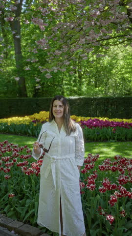 Woman exploring vibrant tulip garden in lisse, netherlands, surrounded by colorful flowers and lush greenery, capturing the essence of springtime in europe.