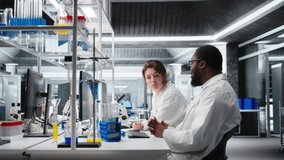 Lab chemists inspect liquids in test tube, looking for breakthroughs during clinical trials. Team of research facility professionals at workbench comparing chemicals vials, testing formula, camera A - Powered by Shutterstock - Get 15% off with code: PIKWIZARD15