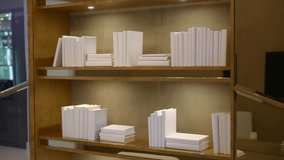 Bookshelf looks clean and cozy with white books and warm light. Gold wall adds soft glow. Simple lines and calm tones make space feel fresh and modern - Powered by Shutterstock - Get 15% off with code: PIKWIZARD15
