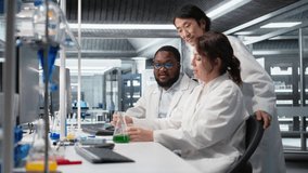 Multiracial researchers in lab inspecting liquids in test tube, looking for breakthroughs during clinical trials. Multiethnic employees comparing chemicals vials, testing right formula, camera A - Powered by Shutterstock - Get 15% off with code: PIKWIZARD15